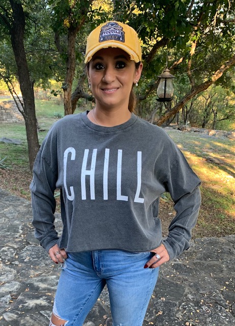 Women wearing a mustard-colored hat and gray “CHILL” sweatshirt